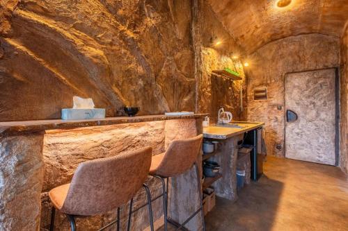 a kitchen with a bar with a stone wall at Apartmány v Podzámčí v blízkosti zámku Blatná in Blatná