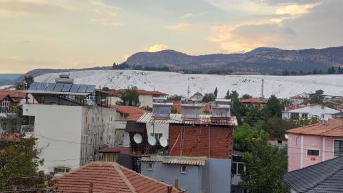 a city with roofs and a snow covered mountain at Engin HOME in Pamukkale