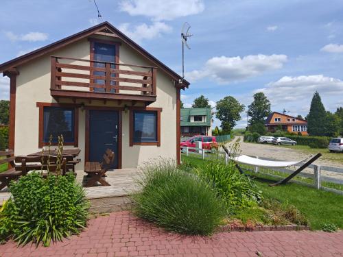 una pequeña casa con una mesa de picnic y un banco en Przystań Semlińska, en Semlin