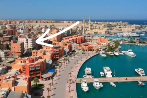 an airplane flying over a harbor with boats in the water at Marina Bay Elegance Room Balcony Overlooking Luxury Yachts in Hurghada
