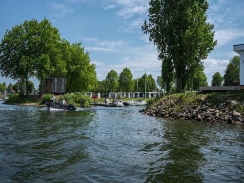 a group of boats on a river with trees at Luxurious holiday home nearby the Lower Rhine in Maurik