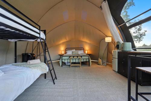 a bedroom with a bed and a table in a tent at Cloud Nine Tent #3 - The Oak Oasis in Hermosa