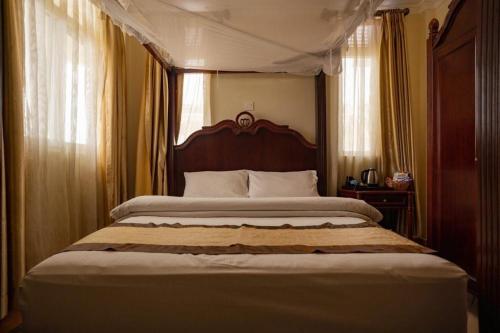 a bedroom with a large bed with a canopy at Island Paradise Inn in Ngambo
