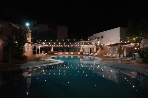 a swimming pool at night with lights on it at Hotel Club Perla in Casalabate