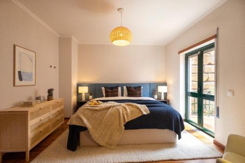 a bedroom with a bed and a dresser and a window at Wave Song Villa in Santo Isidoro