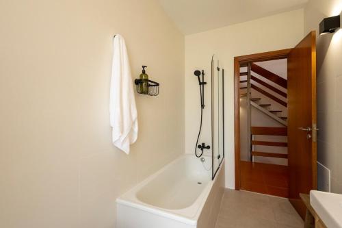a bathroom with a bath tub and a sink at Wave Song Villa in Santo Isidoro