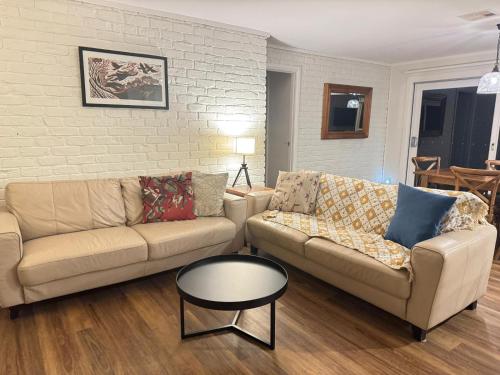 a living room with two couches and a coffee table at Serene Farm-Style Escape 4 Bed Home and Private Guest House 