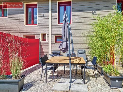 a table with an umbrella in front of a building at les piafs du der 1 in Joncreuil