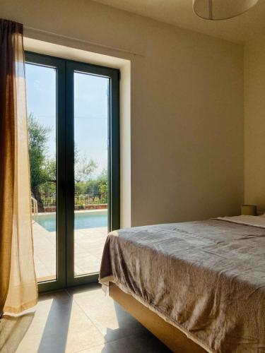 a bedroom with a bed and a sliding glass door at Mitso's House Mani in Exochori