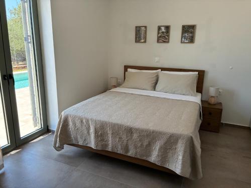 a bedroom with a bed and a large window at Mitso's House Mani in Exochori