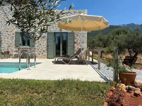 a patio with an umbrella next to a pool at Mitso's House Mani in Exochori