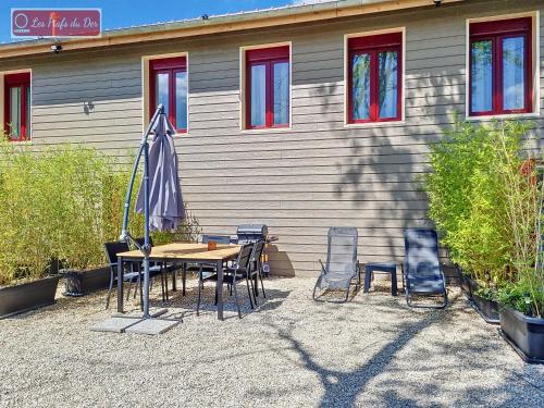 a table and chairs and an umbrella in front of a building at les piafs du der 1 in Joncreuil