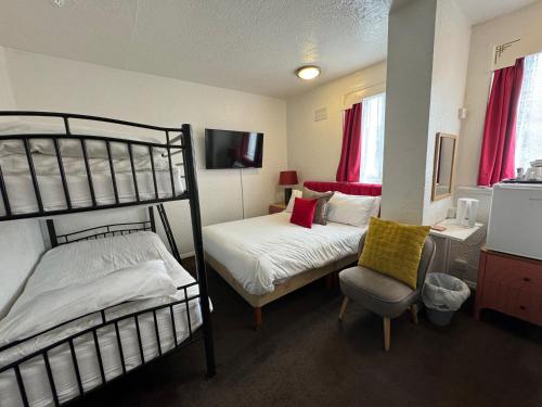 a bedroom with two bunk beds and a chair at The Scala Hotel in Blackpool