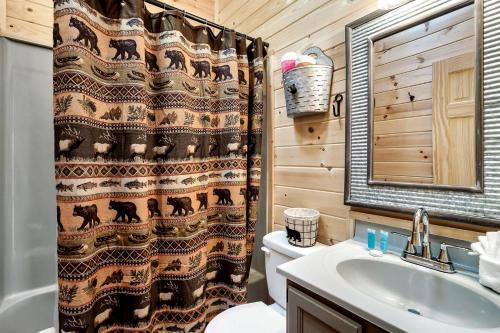 ein Badezimmer mit Toilette und Duschvorhang in der Unterkunft Magnificent Cabin with Hot-tub and Hiking Trails Near in Gatlinburg, Tennessee in Cartertown