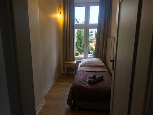 a small bedroom with a bed and a window at DK Apartamenty Mazurskie in Olsztyn