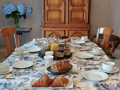 a table topped with croissants and orange juice and orange juice at Chambres D'hôtes De Kerantum in Mahalon