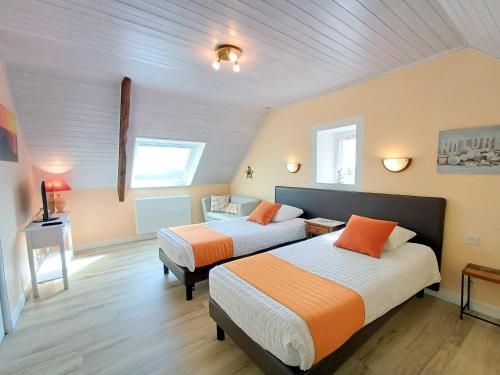 a bedroom with two beds and a table in it at Chambres D'hôtes De Kerantum in Mahalon