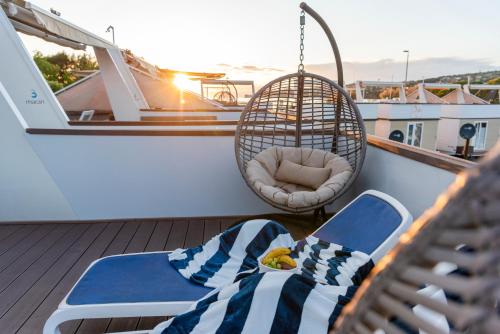 a balcony on a boat with a bed and a swing at Ocean Beauty Beachfront Boat House in Portorož with Sea View and Jacuzzi in Portorož