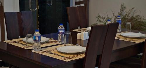 a table with plates and bottles of water on it at Kandy Alpine Breeze in Kandy
