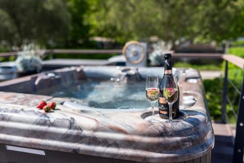 una vasca idromassaggio con una bottiglia e 2 bicchieri di vino di Floating Seahouse Ocean Beauty a Portoroz