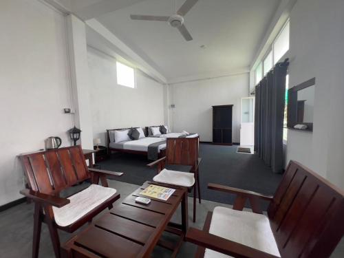 a living room with wooden chairs and a couch at Kandy Alpine Breeze in Kandy