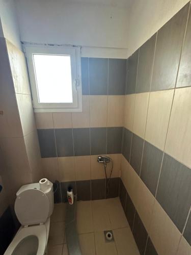 a bathroom with a toilet and a window at Yucca house in Elani