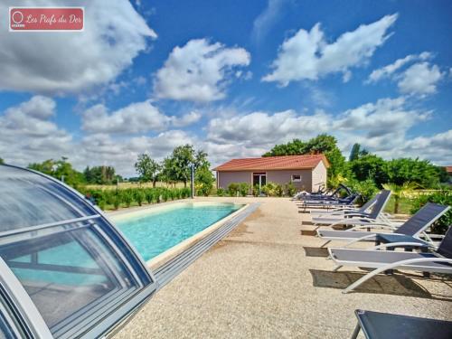 a row of lounge chairs next to a swimming pool at les piafs du der 1 in Joncreuil