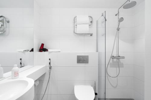 a white bathroom with a shower and a toilet at Omena Hotel Turku Kauppiaskatu in Turku