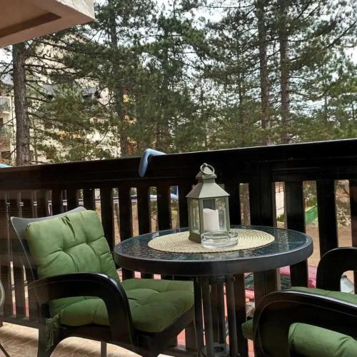 a table and chairs on a deck with a lantern at Simic Apartmani Tara in Kaludjerske Bare