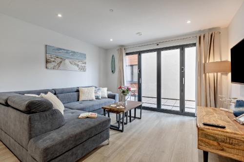 una sala de estar con un sofá y una mesa en 2 Putsborough - Luxury Apartment at Byron Woolacombe, only 4 minute walk to Woolacombe Beach!, en Woolacombe