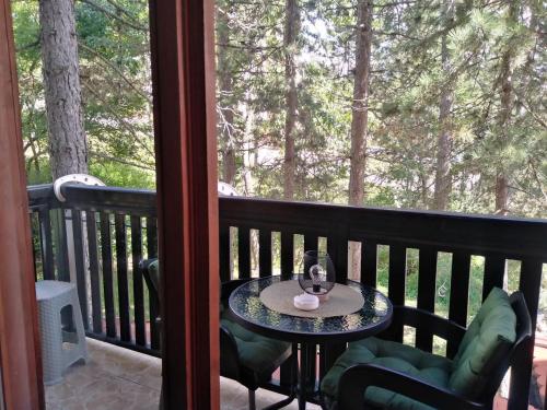 a table and chairs on a balcony with a window at Simic Apartmani Tara in Kaludjerske Bare