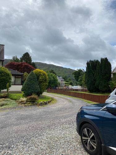 a blue car parked on the side of a road at Garbhein Bed & Breakfast in Kilmelfort