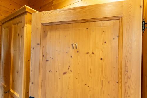 a wooden wall with a door in a cabin at Madlhof in Himmelreich