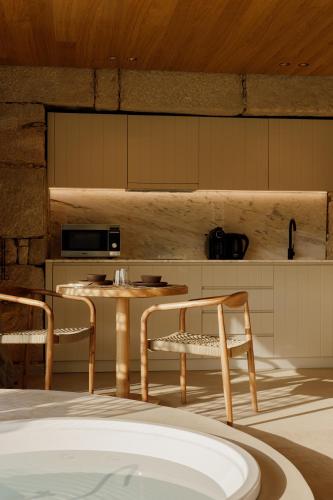 a kitchen with a table and two chairs and a table at Dajas Douro Valley - Exclusive Villas in Casais