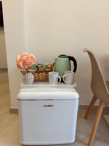 a table with cups and a basket on top of a refrigerator at Amor home b&b - 200m dalla metro A Subaugusta in Rome