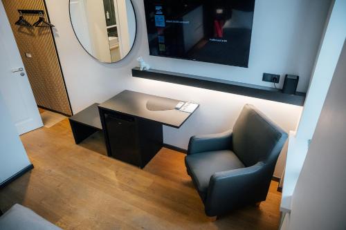 a room with a chair and a table and a mirror at Albert Studio in Art Nouveau building with AC Top location near old town in Rīga