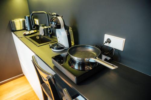 a kitchen counter with a pan on a stove at Albert Studio in Art Nouveau building with AC Top location near old town in Rīga