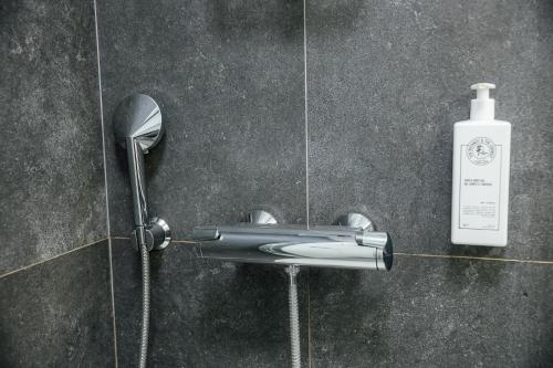 a shower with a hair dryer and a bottle of shampoo at Albert Studio in Art Nouveau building with AC Top location near old town in Rīga