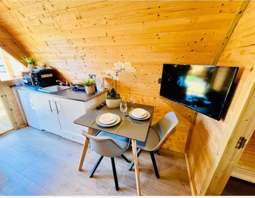 a small kitchen with a table and chairs in a tiny house at Woodlakes Park By Liv Retreats in Kings Lynn