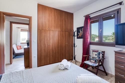 a bedroom with a bed and a tv and a window at Selbesi Holiday Cottage in the countryside - Elevated View in Kómi