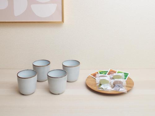four cups on a table with a plate of food at tokyo Japandi apartment ikebukuro in Tokyo