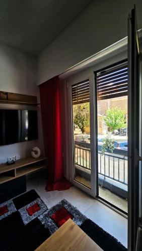 a living room with a large sliding glass door to a balcony at Chalkida Center Hideaway in Chalkida
