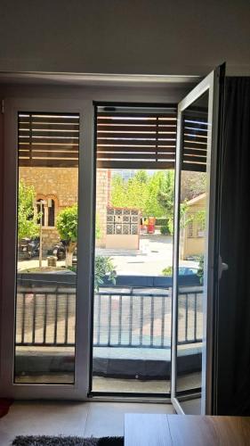 a room with two sliding glass doors looking out at a balcony at Chalkida Center Hideaway in Chalkida