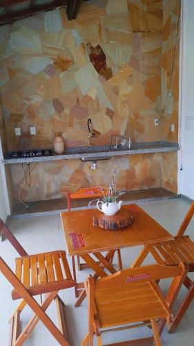 a wooden table with two chairs and a sink at Chalés Vista da Serra in Tiradentes