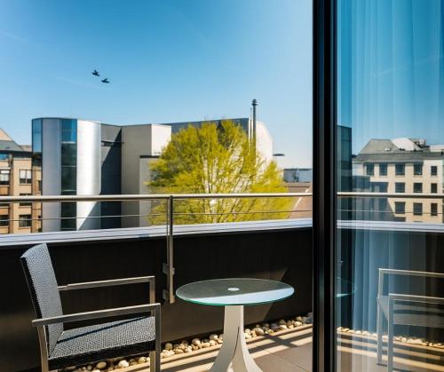 a table and chairs on a balcony with a view at Plaza Hotel & Living Frankfurt in Frankfurt/Main