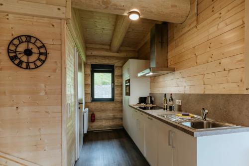 a kitchen with wooden walls and a clock on the wall at Clofers Leisure Lodges Jenig in Jenig