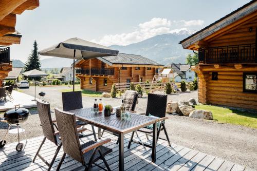 a table with chairs and an umbrella on a patio at Clofers Leisure Lodges Jenig in Jenig