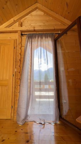 a window with a curtain in a room at Gusinje View in Gusinje