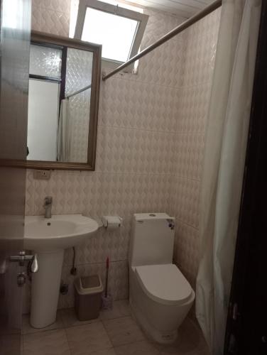 a bathroom with a toilet and a sink and a mirror at Avi-Pension in Addis Ababa