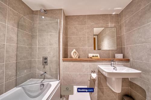 a bathroom with a sink and a tub and a shower at 3 Bedroom Apartment By Paul & Malin Properties Short Lets & Serviced Accommodation Stretford With Gym Access in Manchester